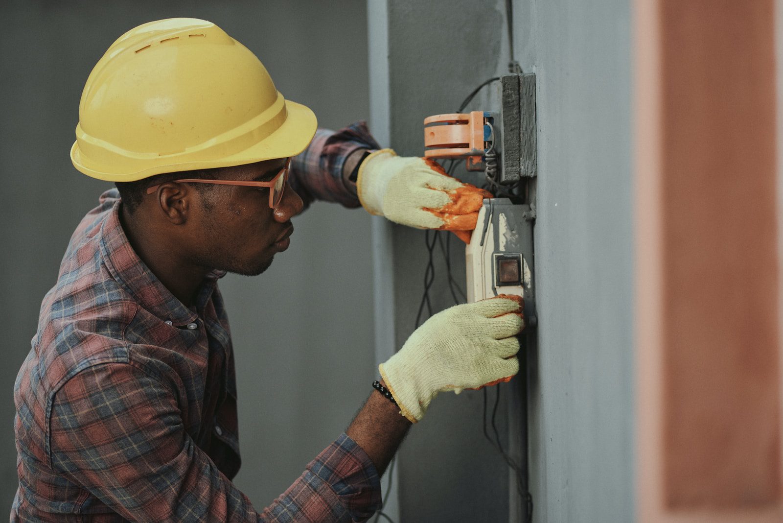 shallow focus photo of man fixing steel cable