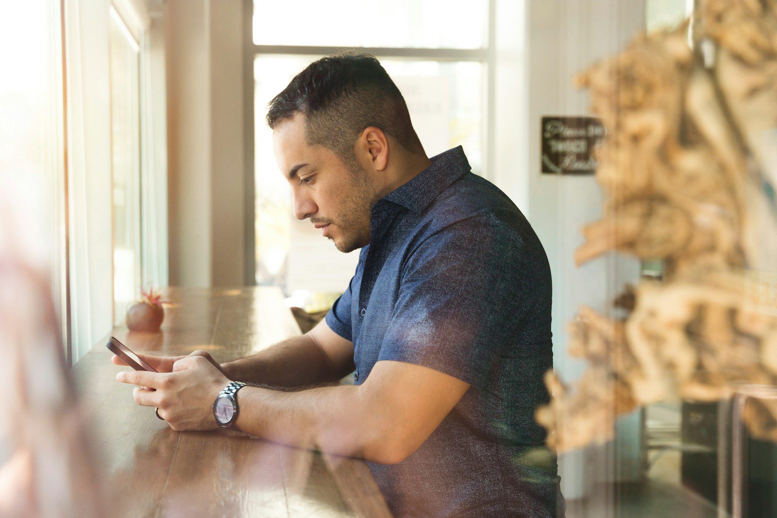 Photo by LinkedIn Sales Solutions man in black button-up shirt holding smartphone