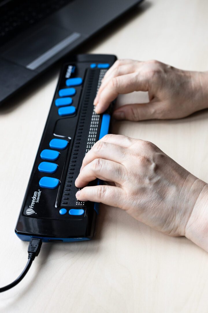 Moscow, Russia - June 5, 2021: woman reading with Focus 40 Blue Braille Display. Freedom Scientific is the largest manufacturer of assistive technology products for blind and low vision people Learner using assistive technology.